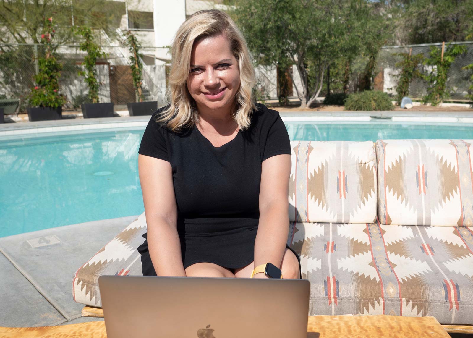 Lisa Burford working on a laptop while sitting by a pool in Palm Springs, California